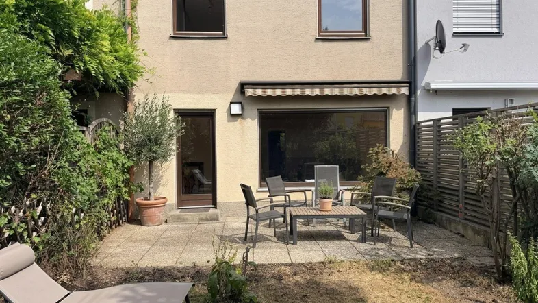 Gemütliche Terrasse mit Gartenmöbeln und Blick ins Grüne, ideal für entspannte Stunden im Freien.