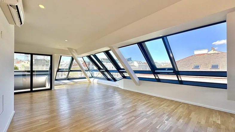 Helles Wohnzimmer mit großen Schrägfenstern, Parkettboden und Klimaanlage, bietet einen weiten Stadtblick.