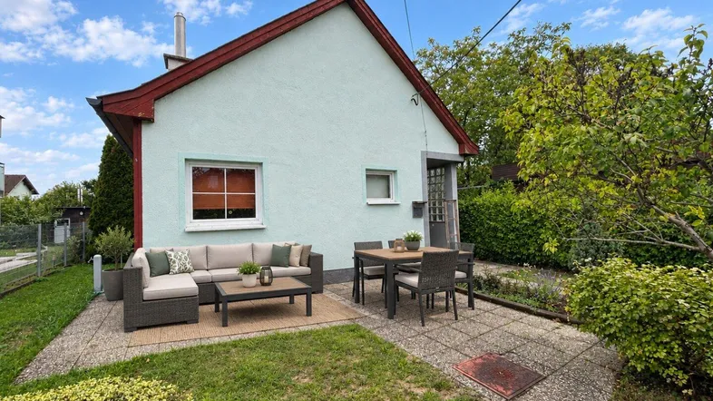 Gemütliche Terrasse mit Sitzgelegenheiten und Essbereich neben dem Haus im Grünen.