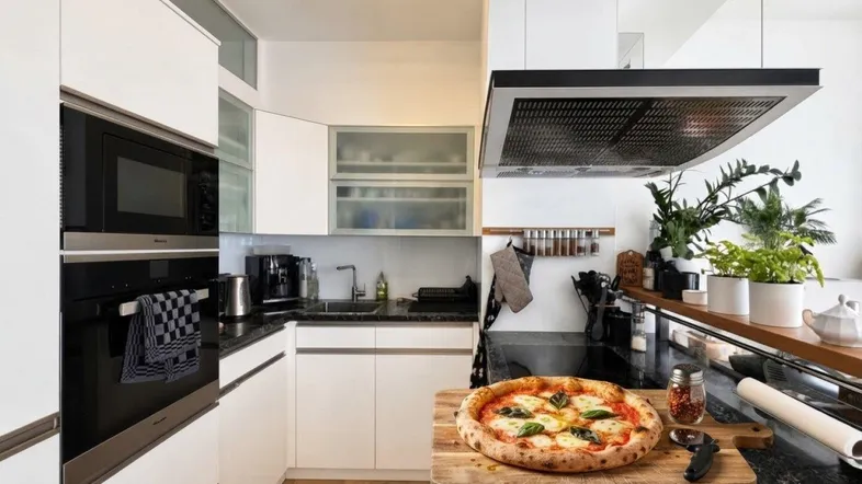Moderne Küche mit weißen Schränken, schwarzer Marmorarbeitsplatte und integrierten Geräten sowie Holzboden.