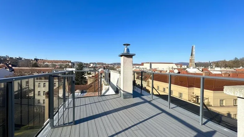 Geräumige Dachterrasse mit modernem Glasgeländer und weitem Blick über die Stadt.