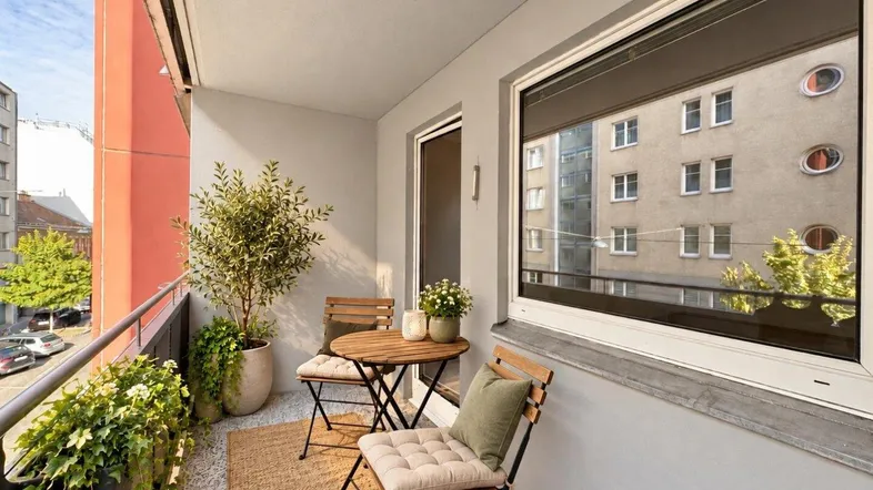 Gemütlicher Balkon mit Sitzgelegenheiten und Pflanzen, ideal zum Entspannen im Freien.