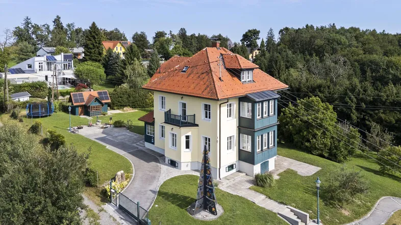 Luftaufnahme des Anwesens mit großem Garten, Zufahrt und umliegender Natur.