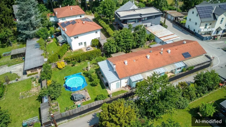 Luftaufnahme einer Wohnsiedlung mit mehreren Häusern, Gärten und einem Aufstellpool.