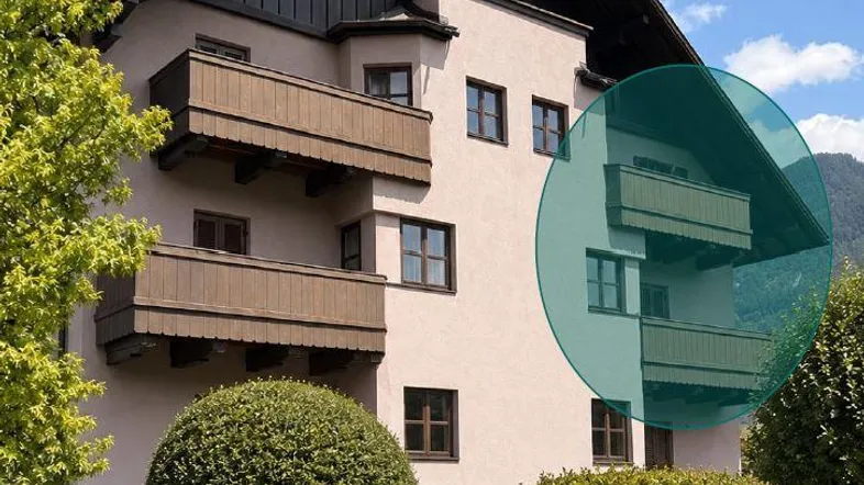 Traditionelles Gebäude mit mehreren Holzbalkonen und Satteldach, umgeben von gepflegter Gartenanlage.