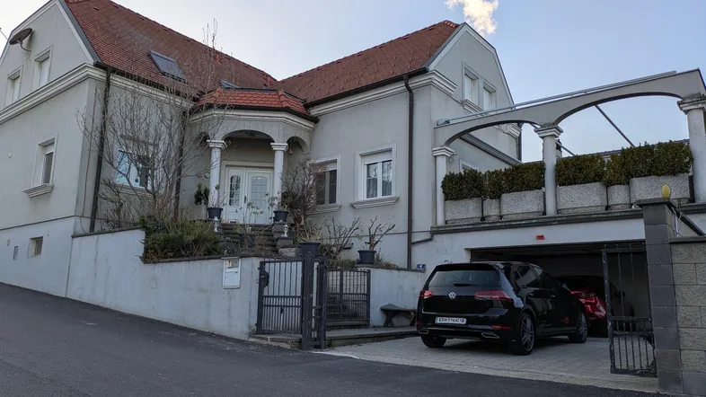 Einfamilienhaus mit Garage und gepflegtem Vorgarten, von der Straße aus gesehen.