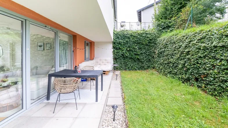Große gepflasterte Terrasse mit Essbereich und direktem Zugang zum privaten Garten.