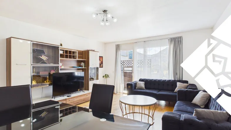 Helles Wohn- und Esszimmer mit modernem Mediamöbel, bequemen Sofas und Zugang zum Balkon.