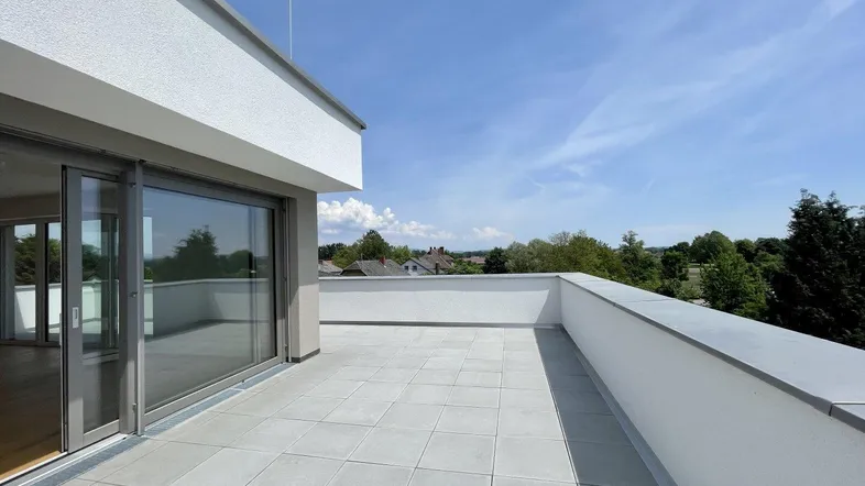 Geräumige Dachterrasse mit modernen Fliesen und weitem Blick über die Umgebung.