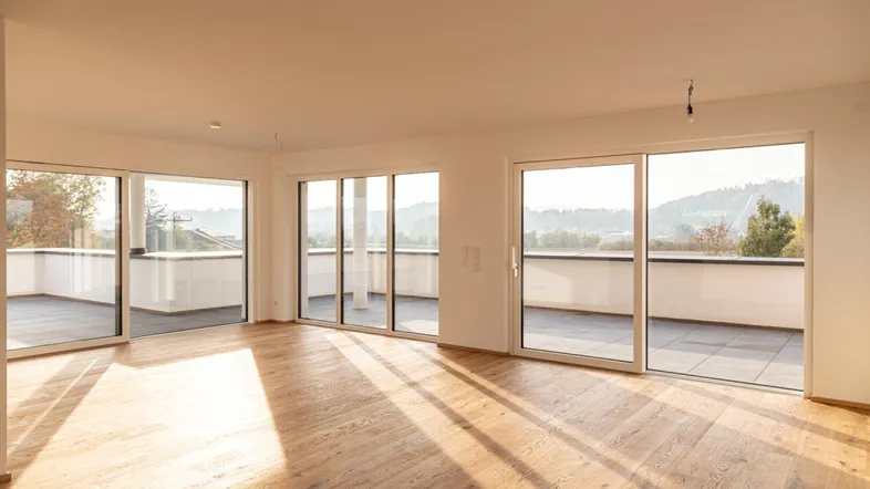 Helles, geräumiges Zimmer mit Holzboden und großen Schiebetüren zur Terrasse mit Weitblick.