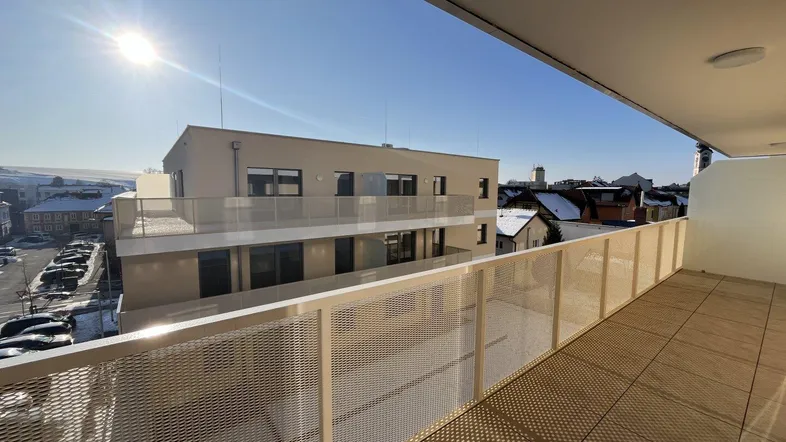 Sonnige Terrasse mit moderner Brüstung und Blick über die verschneite Stadtlandschaft.