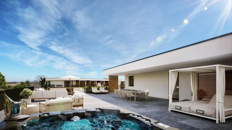 Großzügige Dachterrasse mit Whirlpool, Essbereich und Lounge-Möbeln unter blauem Himmel.