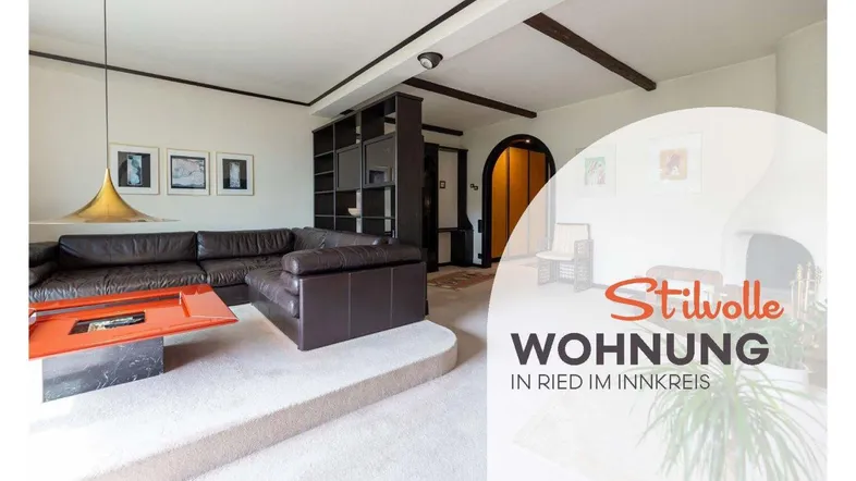 Stilvolles Wohnzimmer mit Ledersofa, Kamin und Teppichboden, akzentuiert durch dunkle Holzbalken.