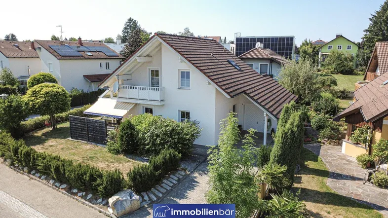 Luftaufnahme eines Einfamilienhauses mit Garten, Zufahrt und umliegender Wohngegend.