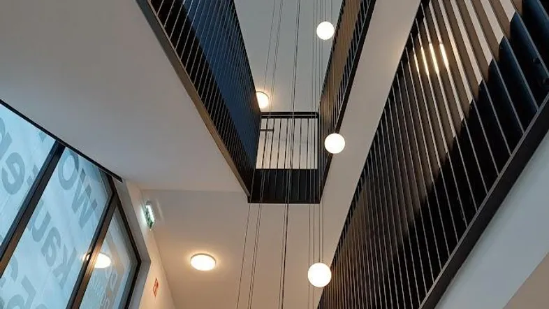 Modernes Treppenhaus mit eleganten Hängelampen und minimalistischem Design in einem Mehrfamilienhaus.