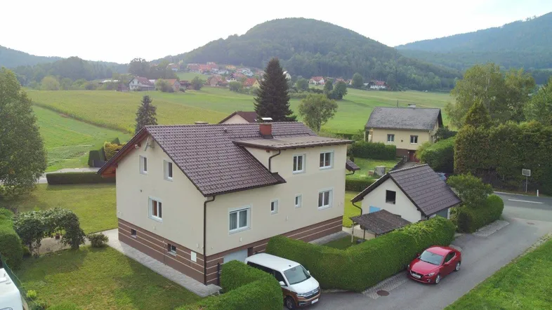 Drohnenaufnahme eines Einfamilienhauses mit gepflegtem Garten und ländlicher Umgebung.
