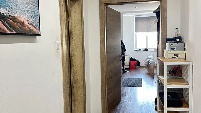 Heller Flur mit modernen Fliesen und Holztüren, der zu weiteren Räumen führt.