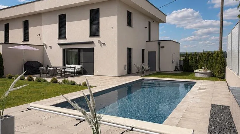 Modernes Haus mit großem Pool, gepflegtem Garten und Terrasse für entspannte Stunden im Freien.