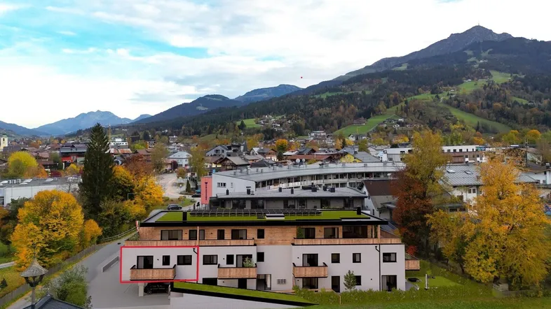 Moderne Wohnanlage in alpiner Umgebung mit Bergblick und Balkonen.