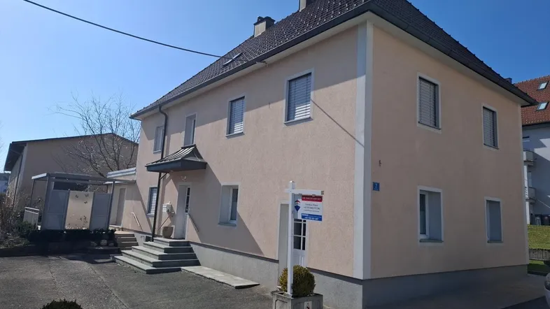 Helles Einfamilienhaus mit gepflegter Fassade und Vorgarten, bereit für neue Bewohner.