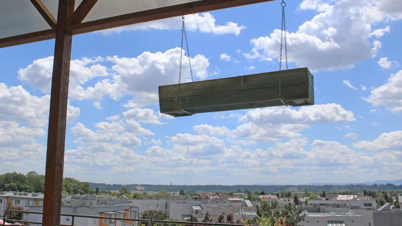Überdachte Terrasse mit weitem Blick über die Stadt und blauen Himmel, ideal zum Entspannen.