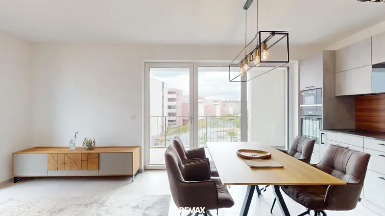 Moderner Essbereich mit Holztisch, bequemen Stühlen und Zugang zu einem Balkon mit Stadtblick.