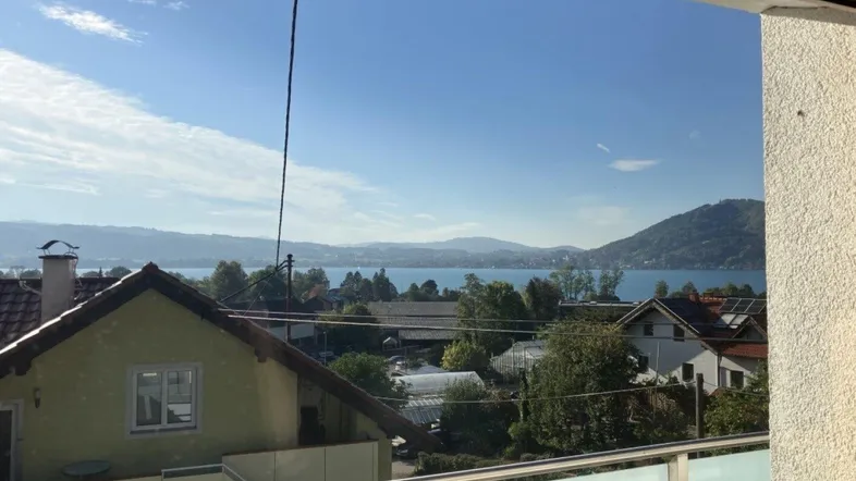 Panoramablick vom Balkon auf den See und die umliegende Landschaft mit Häusern.