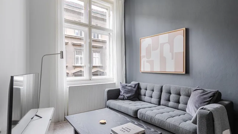 Helles Wohnzimmer mit modernem Sofa, Couchtisch und Blick auf die Stadtstraße.