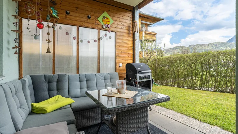 Gemütliche Terrasse mit Loungemöbeln, Grill und Blick ins Grüne.