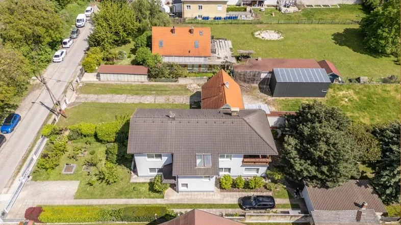 Luftaufnahme eines Wohnhauses mit Garten und umliegenden Grundstücken in ländlicher Umgebung.