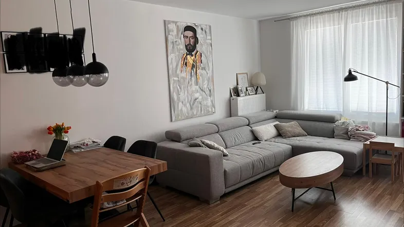 Heller Wohn- und Essbereich mit modernem Sofa, Holztisch und Parkettboden, ideal für Familien.