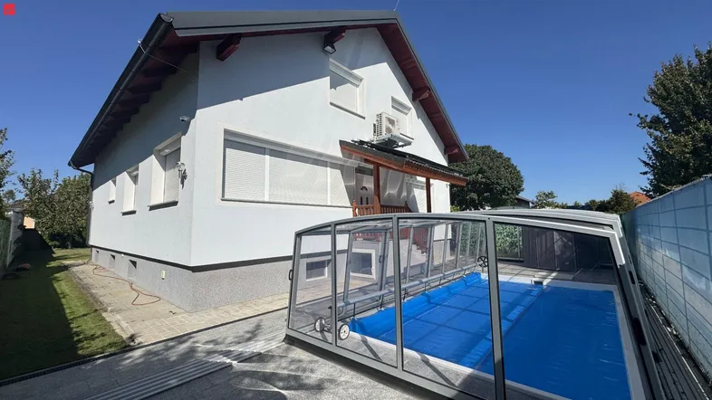 Seitenansicht des Hauses mit überdachtem Pool und Gartenbereich.