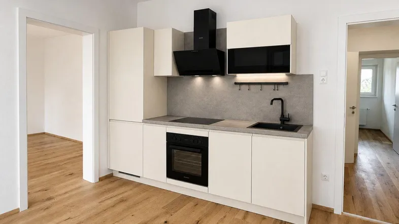Moderne Einbauküche in hellem Beige mit schwarzer Spüle und Kochfeld, bereit zur Nutzung.