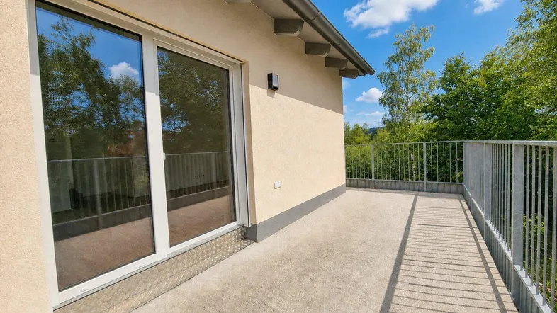 Geräumiger Balkon mit Metallgeländer und Blick ins Grüne, ideal für entspannte Stunden im Freien.