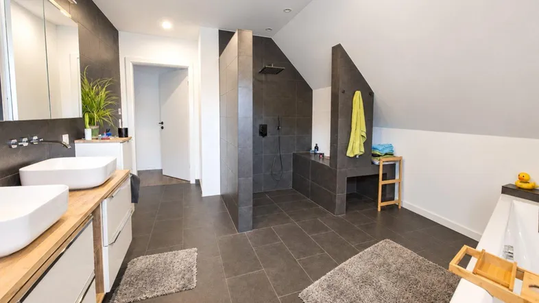 Modernes Badezimmer im Dachgeschoss mit Doppelwaschbecken, großer begehbarer Dusche und Badewanne.