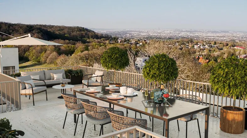 Große Dachterrasse mit Esstisch, Lounge-Bereich und weitem Blick über die Stadt und die umliegende Landschaft.