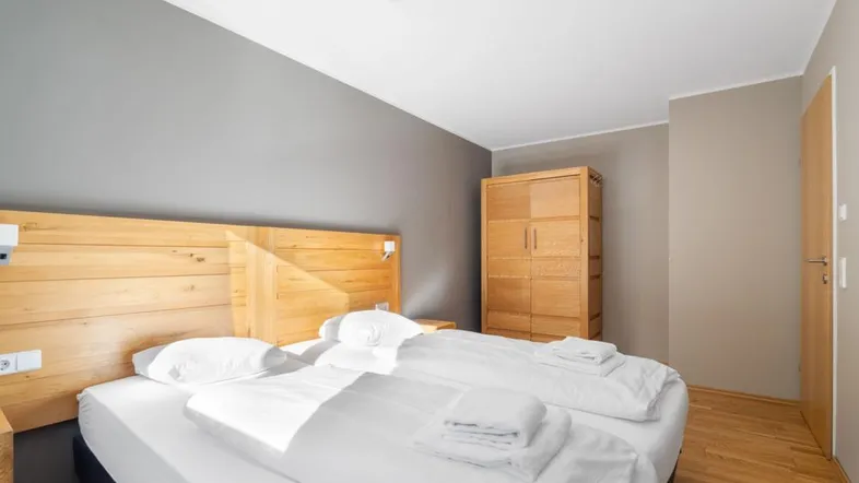 Gemütliches Schlafzimmer mit Holzbett, Nachttischen und einem Kleiderschrank.