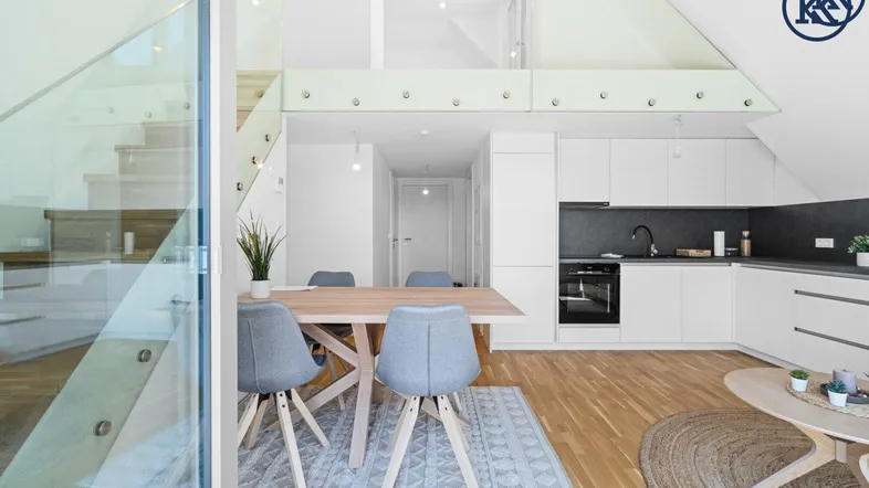 Moderne offene Küche mit Essbereich, Wohnzimmer und Galerie in einem hellen Dachgeschoss.