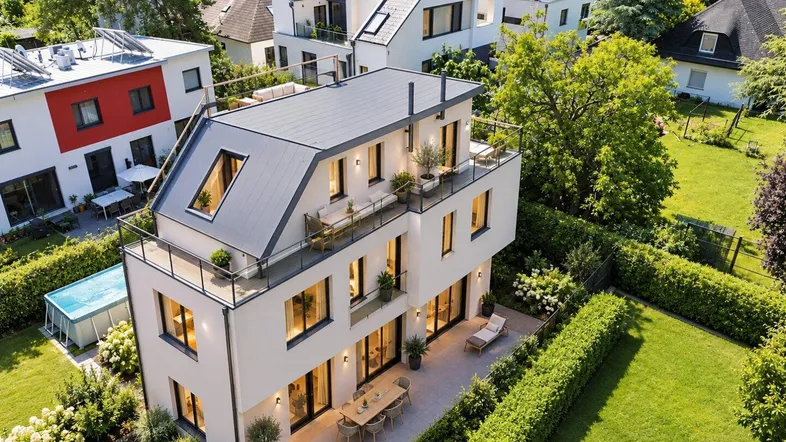 Moderne Villa mit großzügigen Terrassen, gepflegtem Garten und Pool in grüner Umgebung.