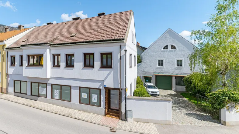 Vorderansicht des Gebäudes mit angrenzender Straße und Einfahrt zum hinteren Bereich.