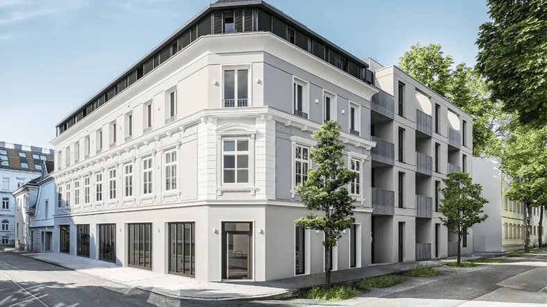Eckgebäude mit einer Kombination aus klassischer und moderner Architektur in städtischer Umgebung.