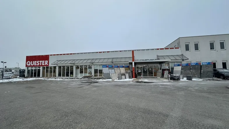 Außenansicht eines Baumarktes mit großem Parkplatz und Schnee auf dem Boden an einem bewölkten Tag.