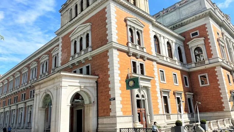 Prächtiges historisches Gebäude mit klassischer Architektur und vielen Fenstern unter blauem Himmel.