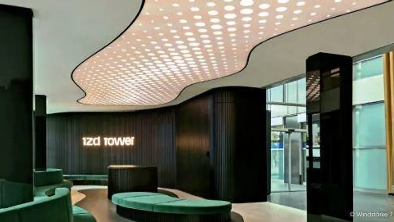 Moderne und futuristische Lobby mit einzigartiger Deckenbeleuchtung und dunklen Akzenten, die eine luxuriöse Atmosphäre schafft.
