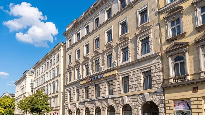 Historisches Gebäude mit klassischer Fassade und vielen Fenstern an einer belebten Straße in der Stadt.
