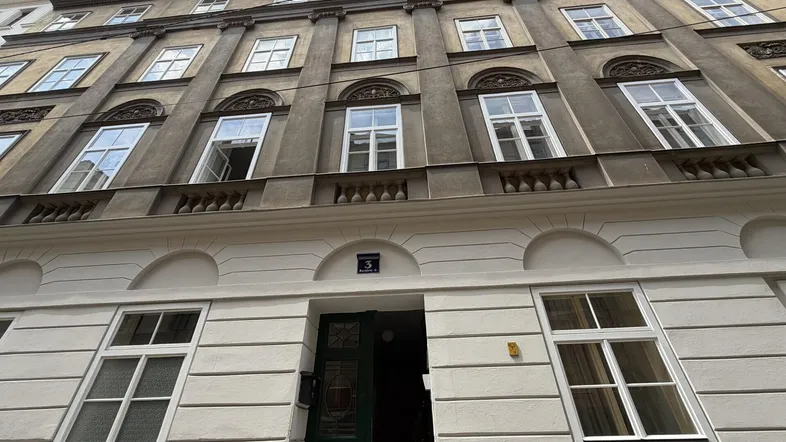 Klassisches Gebäude mit historischer Fassade, großen Fenstern und einem einladenden Eingangsbereich.