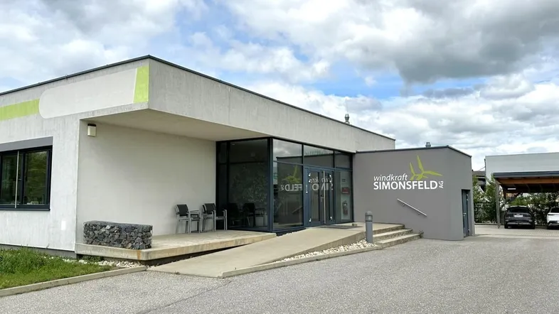 Modernes Bürogebäude mit barrierefreiem Zugang und großzügigem Eingangsbereich unter bewölktem Himmel.