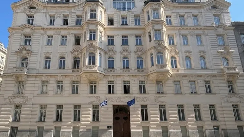 Großes, historisches Gebäude mit vielen Fenstern und dekorativer Fassade unter blauem Himmel.