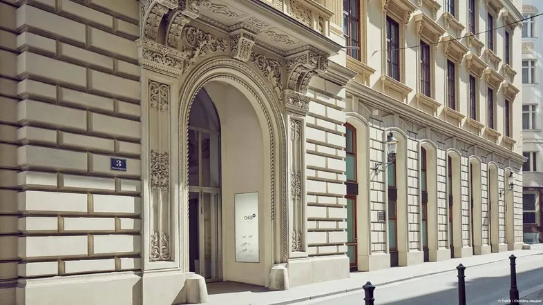 Elegante historische Fassade eines Gebäudes mit reich verzierten Details und einem großen Bogenportal.
