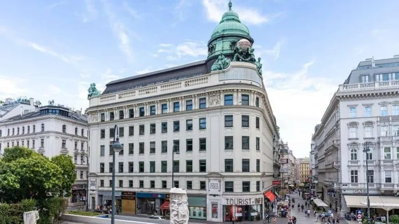 Historisches Gebäude mit markanter Kuppel und belebter Straße in der Stadt.